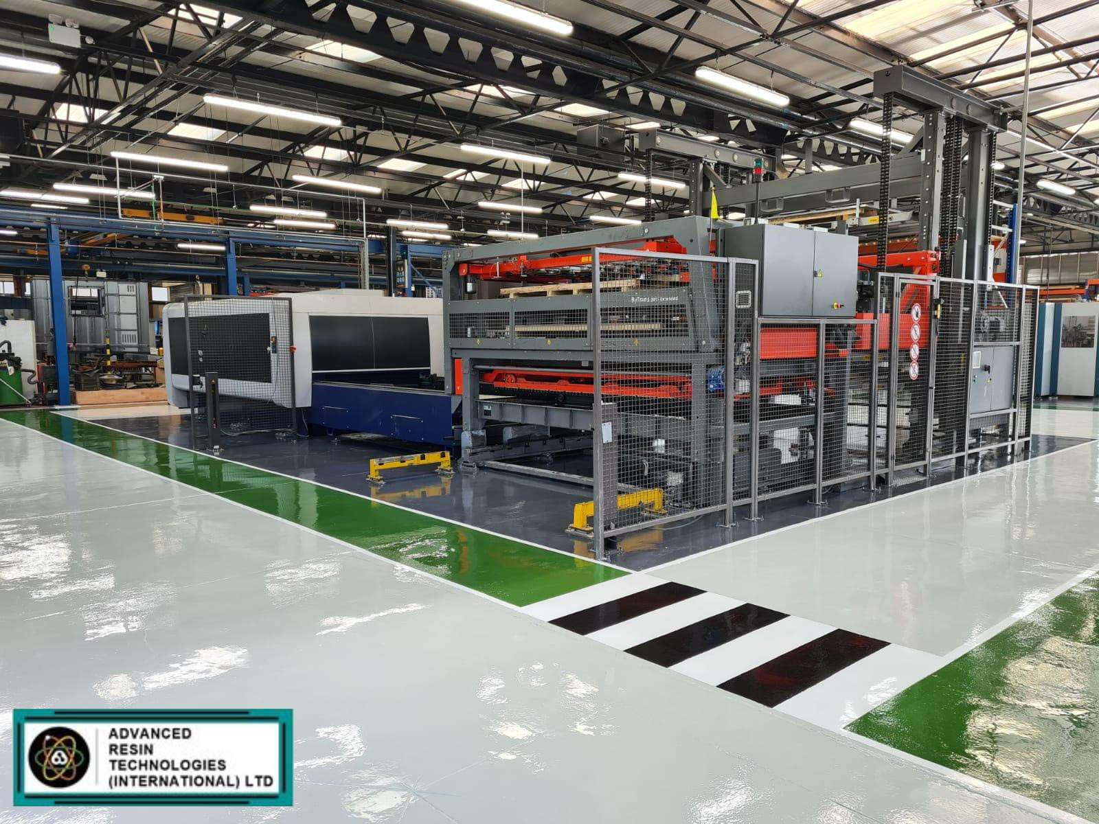 A clean and well-lit factory showcasing a pristine epoxy flooring highlighting its versatility and functionality in an industrial setting