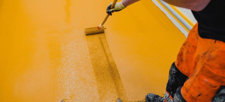 Worker applying polyurethane screed to the floor for beneficial impacts