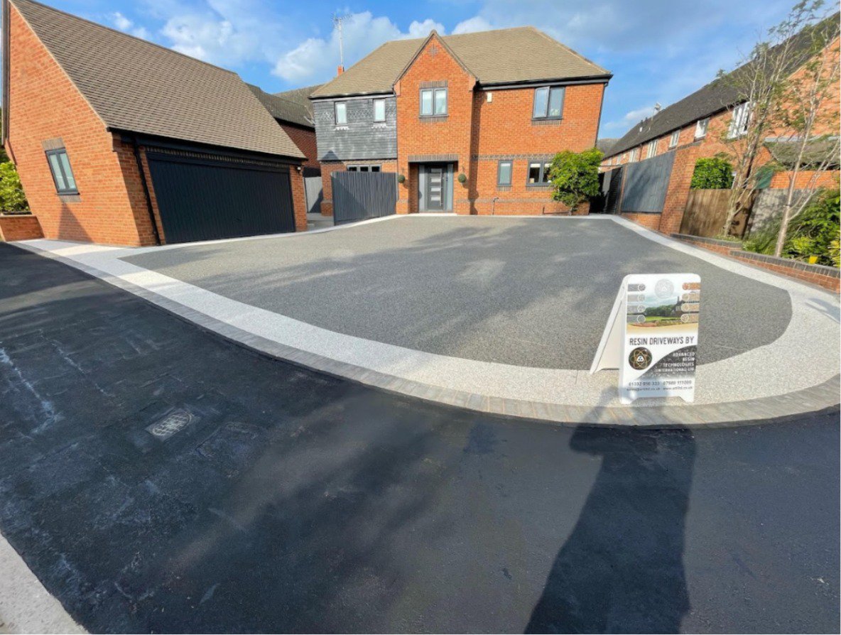 A resin driveway with light grey and charcoal resin with block paving showing the different types of resin drives available for homeowners.