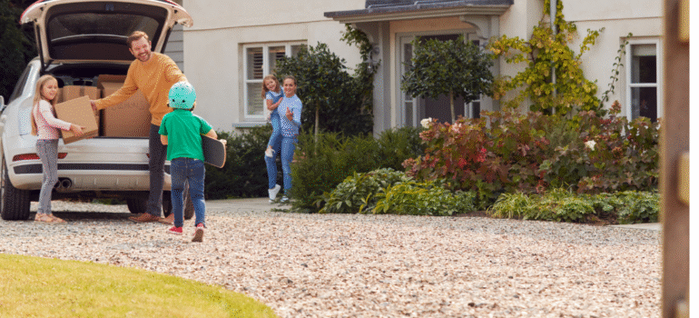 A happy family outside their home with a resin driveway, highlighting the practical benefits and kerb appeal of investing in a resin bound driveway in 2026.