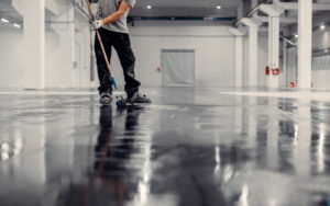 A worker installing a floor made from Sika UCrete UD200 in an industrial building.