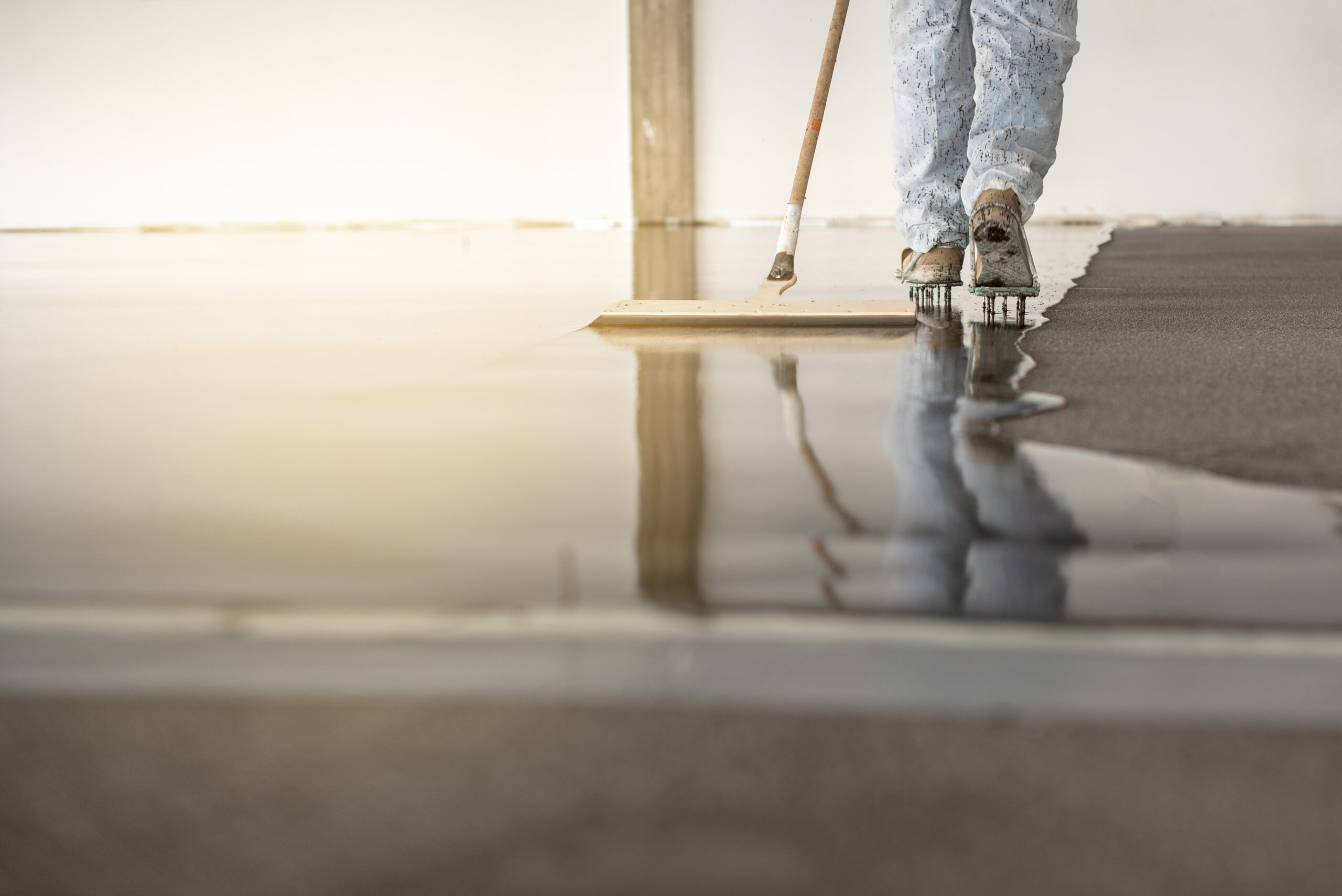 Retail worker cleaning polished commercial flooring, showcasing epoxy floor benefits including easy maintenance, hygiene and long-term durability.